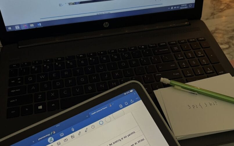 Sülearvuti ja sülearvuti, mis on asetatud puidust töölauale, näidates tootlikkuse ja organiseerimise tööruumi seadistust.